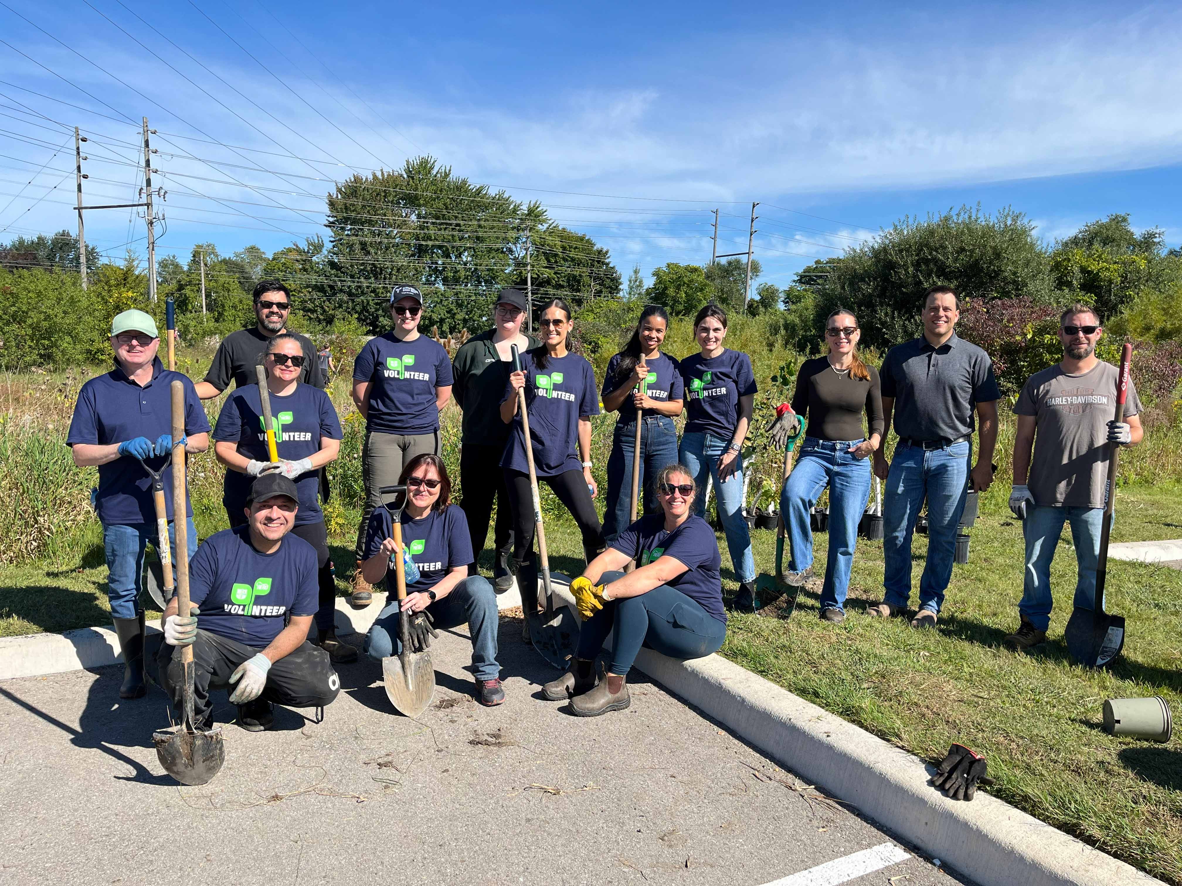 Group of people holding shovels and wearing gloves